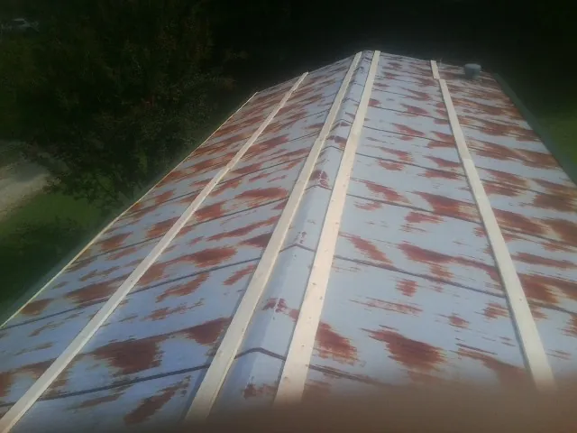 Rusted metal roof panels with new wood purlins before replacement in Woodstock